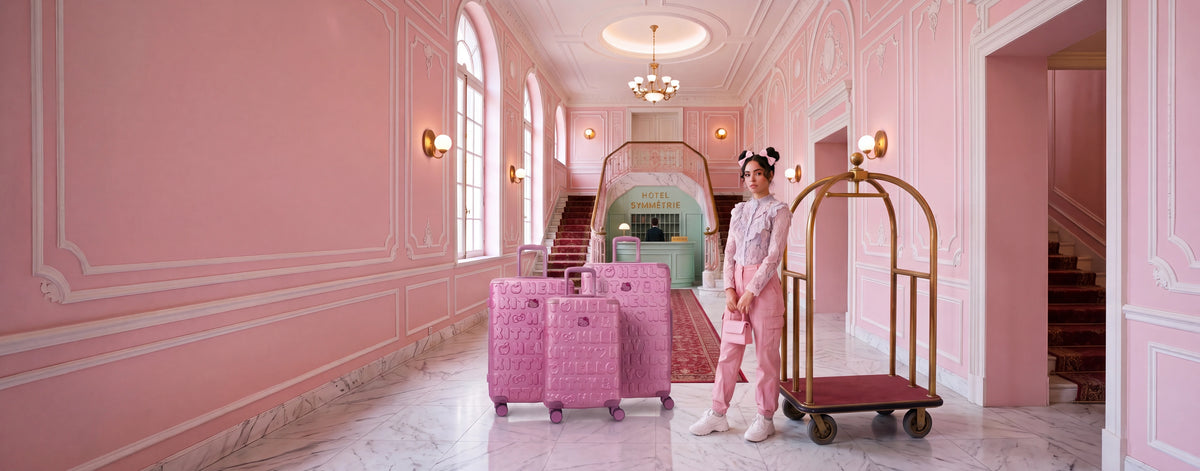 Set de valises Hello Kitty Kuririn rose dans le hall d'un hôtel rose